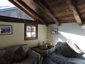 普拉傑拉托的住宿－Baita del Plan，客厅配有两把椅子和一张桌子