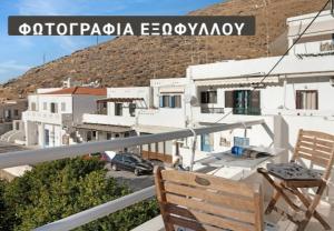 a wooden chair sitting on a balcony with buildings at Panana Irida in Mérikhas
