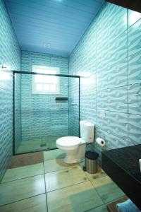 a bathroom with a toilet and a glass shower at Pousada João e Maria Gramado in Gramado +70 photos