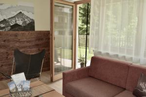 a living room with a couch and a mirror at Hollys Ferienwohnungen in Gerlos