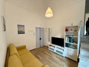 a living room with a couch and a television at BUDELLO Apartament in Alassio
