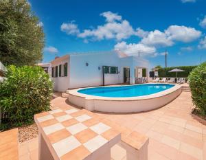 a swimming pool in the backyard of a house at Villa Brehat avec piscine privée in Cala en Porter