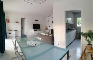 a kitchen and dining room with a blue table and chairs at Villa Brehat avec piscine privée in Cala en Porter