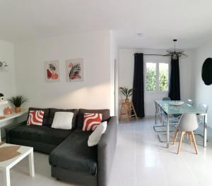 a living room with a black couch and a table at Villa Brehat avec piscine privée in Cala en Porter