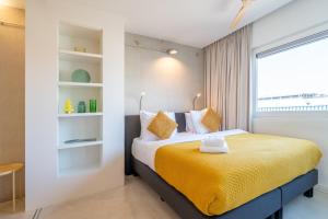 a bedroom with a yellow bed with a window at Houthaven Apartments in Amsterdam
