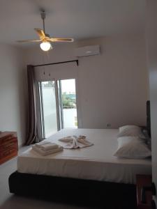 a bedroom with a bed with two towels on it at Blue Infinity in Káto Ássos