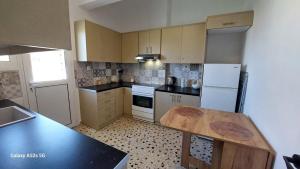 a kitchen with a wooden table and a refrigerator at Blue Infinity in Káto Ássos