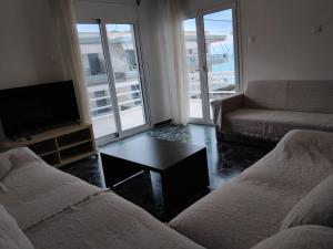 a living room with two beds and a tv and a couch at Blue Infinity in Káto Ássos