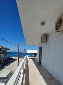 a white building with a balcony with a view of the ocean at Blue Infinity in Káto Ássos