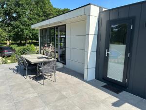 a patio with a table and chairs next to a building at Chalet Emsblick in Walchum