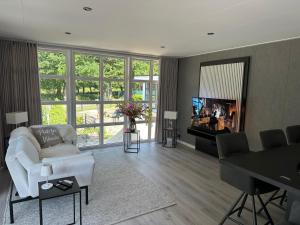 a living room with a white couch and a television at Chalet Emsblick in Walchum