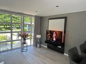 a living room with a flat screen tv on a wall at Chalet Emsblick in Walchum