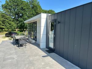 a patio with a table and chairs next to a building at Chalet Emsblick in Walchum