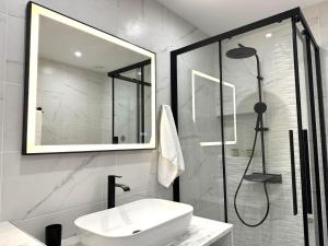 a white bathroom with a sink and a shower at Central Suites Aegina 4 in Egina +49 photos