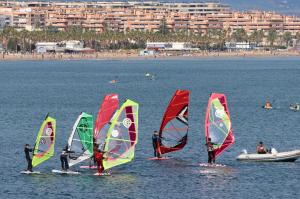 a group of people in the water with windsurfing sails at Manzaneque Rural House in Caudete de las Fuentes
