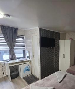 ein Schlafzimmer mit einem Bett und einem Fernseher an der Wand in der Unterkunft AnA in Constanţa + 44 Fotos