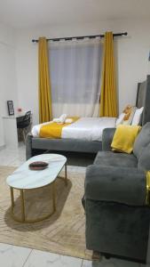 a living room with two beds and a couch and a table at Heritage Homes in Ruiru