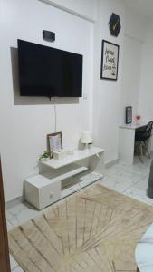 a living room with a tv on a white wall at Heritage Homes in Ruiru