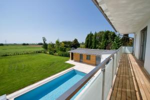 a view from the balcony of a house with a swimming pool at Villa 60, luxuriöse Villa mit Pool, Sauna und großem Garten in Gols
