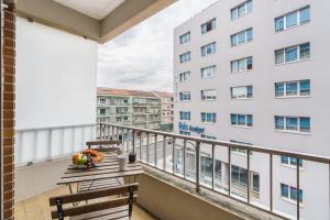 a balcony with a table and chairs and a building at Libertà Lodge Apartment - Minho's Guest in Braga