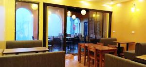 a restaurant with wooden tables and chairs and windows at Cozy Bunk Sa Pa in Sapa +14 photos