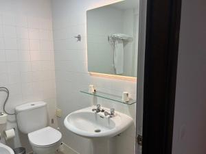 a bathroom with a sink and a toilet and a mirror at Flag Hotel Campo Maior in Campo Maior