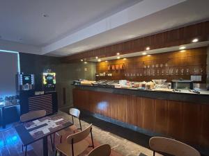 a restaurant with a bar with chairs and a counter at Flag Hotel Campo Maior in Campo Maior