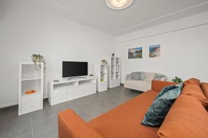 a living room with a couch and a tv at Apartamento 3 Nações in Alvor
