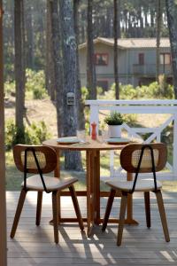a wooden table and two chairs on a deck at VANILLA Lodge in Lacanau-Océan