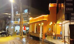 a yellow building on a city street at night at Cozy Bunk Sa Pa in Sapa