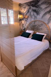 a bedroom with a large bed with white sheets at VANILLA Lodge in Lacanau-Océan