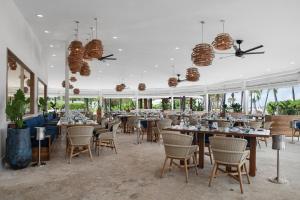 a restaurant with tables and chairs and windows at Blue Haven Resort- All Inclusive in Providenciales
