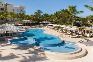a pool at a resort with chairs and umbrellas at Blue Haven Resort- All Inclusive in Providenciales
