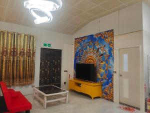 a living room with a tv and a wall with a painting at 湖山沐旅 Hu Shan Mulu in Douliu