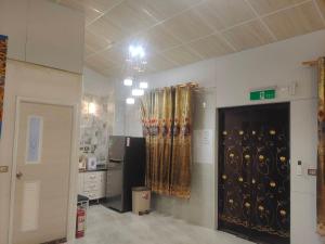 a room with a kitchen with a refrigerator and curtains at 湖山沐旅 Hu Shan Mulu in Douliu