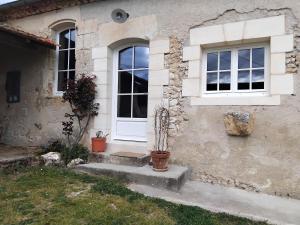 a house with a white door and two windows at Les Hauts de la Crempse chambre d'hôtes in Montagnac-la-Crempse