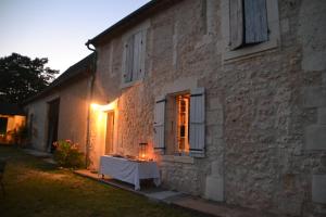 a table sitting outside of a building with a window at Les Hauts de la Crempse chambre d'hôtes in Montagnac-la-Crempse