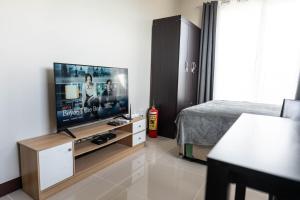 a living room with a flat screen tv in a bedroom at Affordable Condo in Cebu with Great Views in Suba