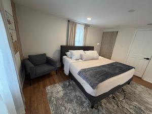 a bedroom with a bed and a chair at Suite Safari in Tampa