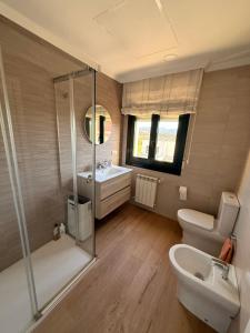 a bathroom with a shower and a toilet and a sink at Chalet Bordones Playa in Bordons