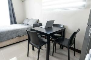 a table with chairs and a laptop on it in a bedroom at Affordable Condo in Cebu with Great Views in Suba