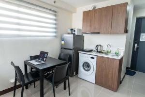 a kitchen with a table and a refrigerator and a washer at Affordable Condo in Cebu with Great Views in Suba +13 photos