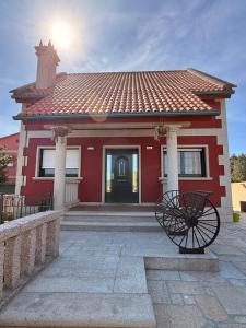 a red house with a red roof at Chalet Bordones Playa in Bordons