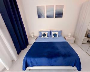 a bedroom with a blue bed and blue curtains at La Mya Aurora in Finale