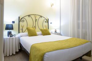 a bedroom with a large bed with a yellow blanket at Alda Centro Zamora in Zamora