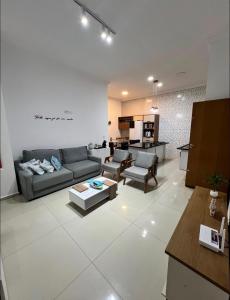 a living room with a couch and a table at Piscina Aquecida Quartos com Ar cond 700m Praia in Peruíbe