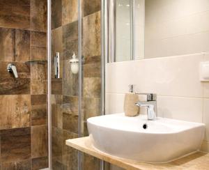 a bathroom with a sink and a shower at Stara Kuźnia Mazurska in Węgorzewo