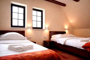 two beds in a room with two windows at Stara Kuźnia Mazurska in Węgorzewo