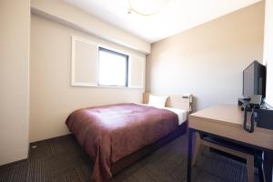a bedroom with a bed and a desk and a television at Sun Hotel Kudamatsu in Hanaoka +38 photos