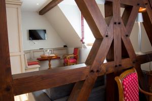 a room with a wooden staircase with chairs and a television at Hotel Spa et Restaurant Au Chasseur in Birkenwald
